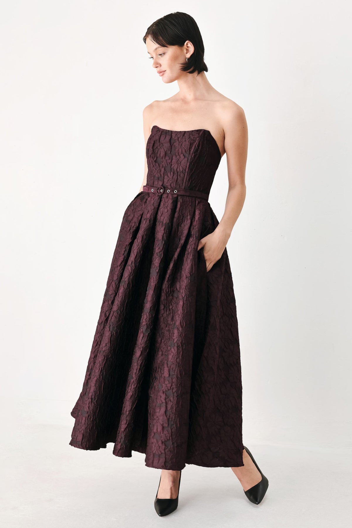 Burgundy Strapless Jacquard Midi Dress with Pockets in Burgundy, three-quarter view with hand in pocket | Lady Black Tie