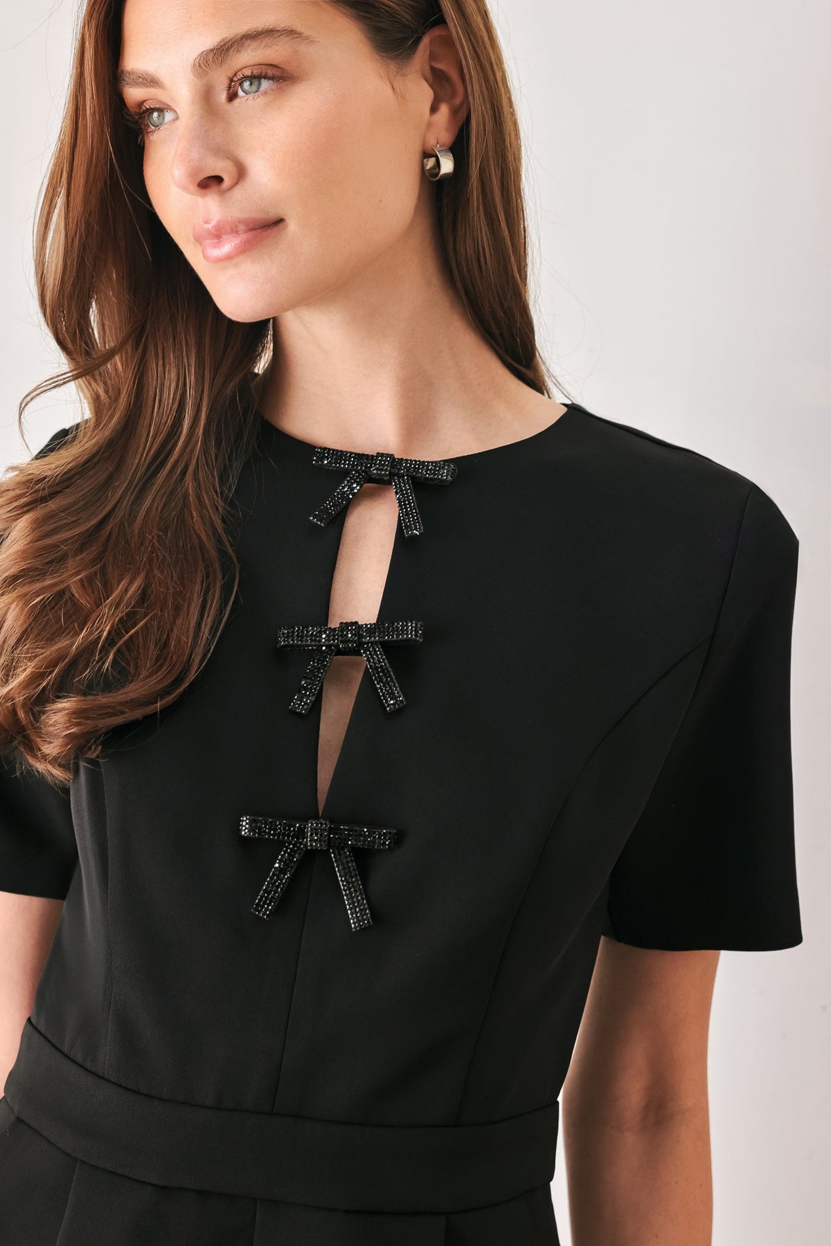 Black Rhinestone Bow Keyhole Romper in Black, close-up of rhinestone bow keyhole neckline | Lady Black Tie
