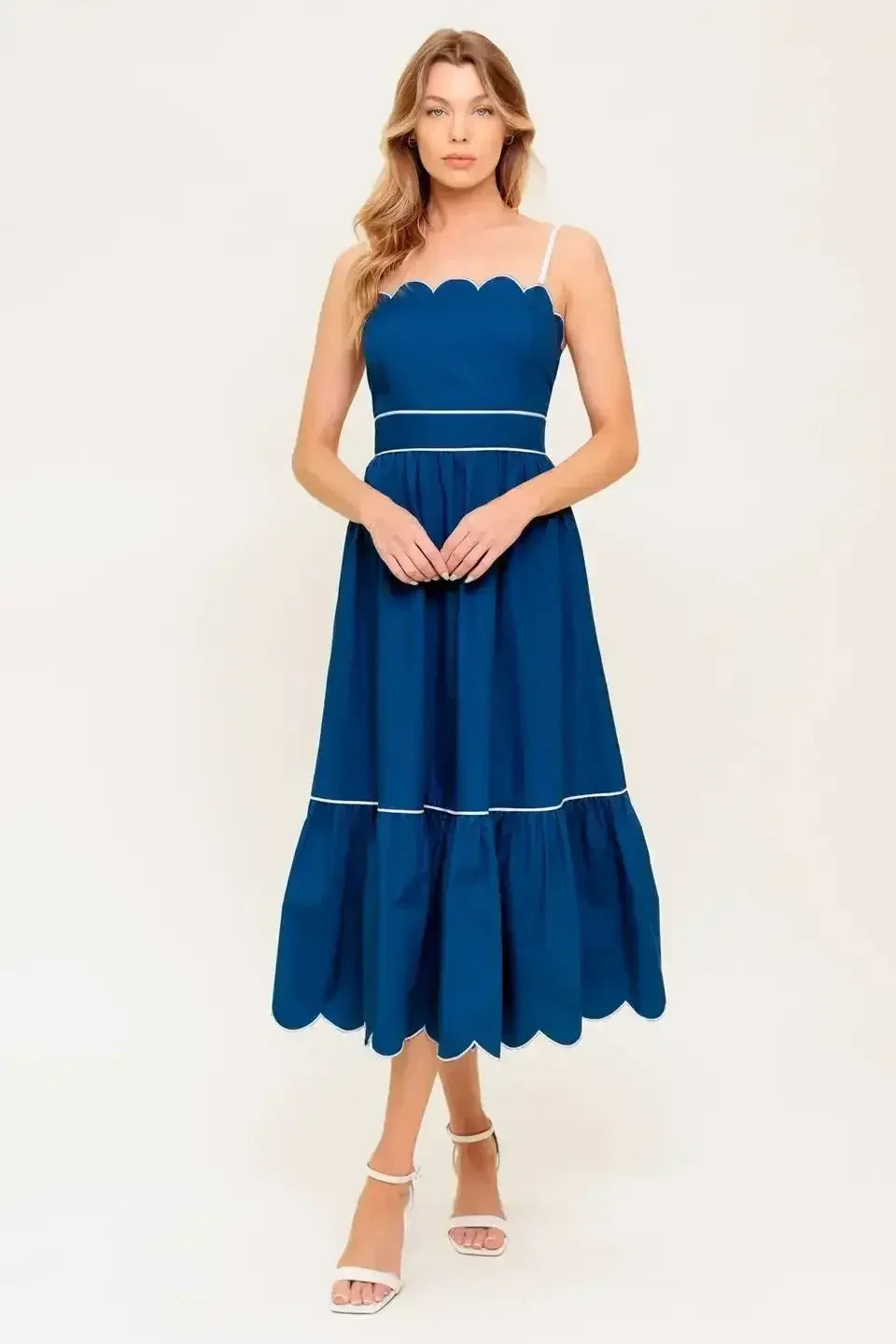 Navy midi dress with a scalloped neckline, sleeve straps, and a ruffled hemline