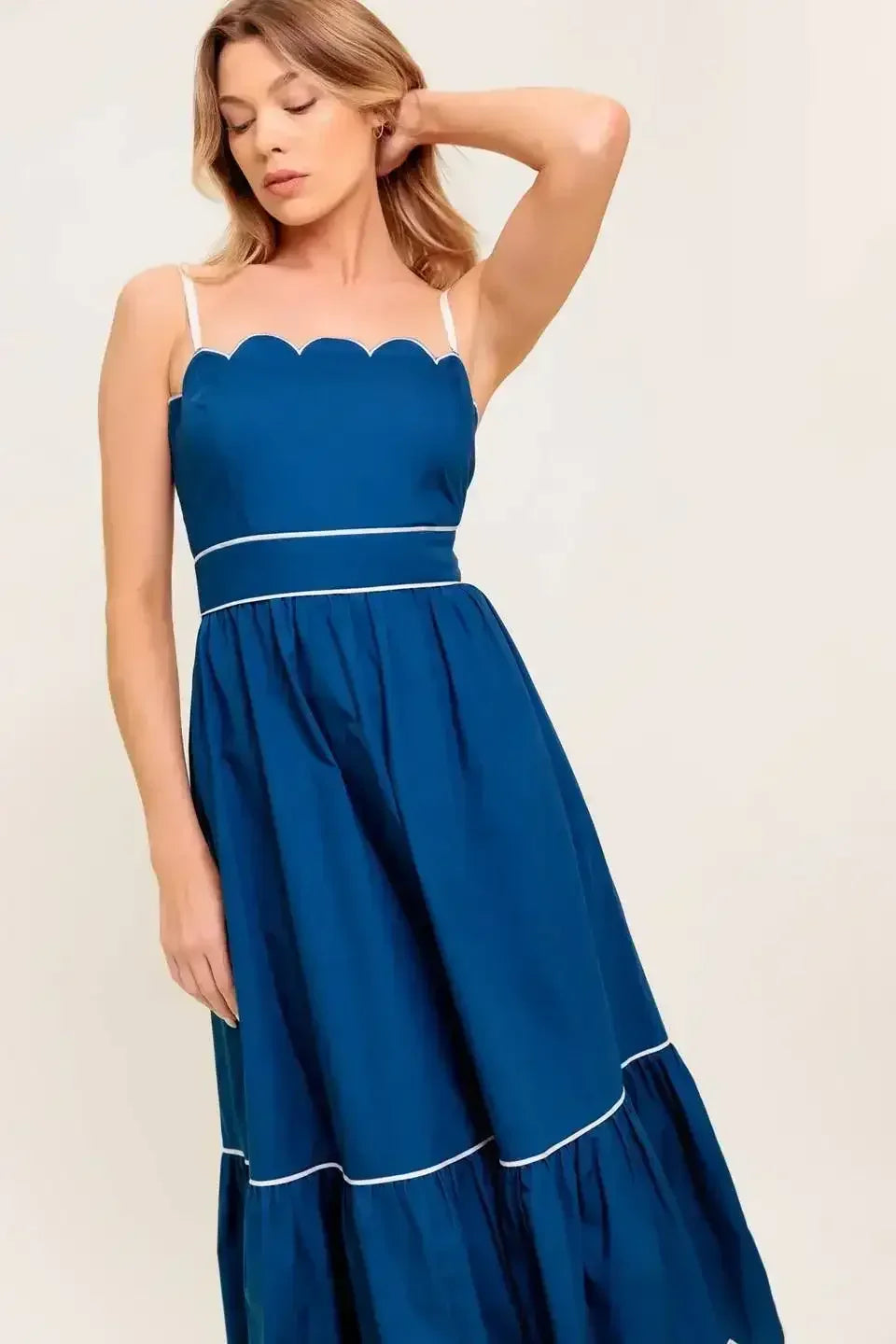 Navy midi dress with a scalloped neckline, sleeve straps, and a ruffled hemline