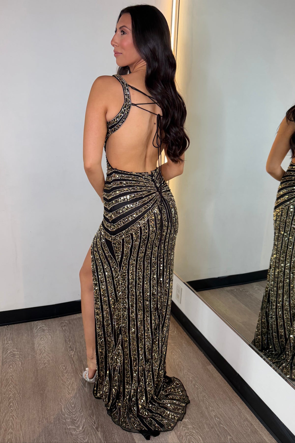 4744 Primavera Couture - Black-Gold Beaded Prom Gown | Lady Black Tie 

The dress is embellished with metallic gold sequins and beads featuring a plunging V-neckline, fitted silhouette, high slit, and open back. 