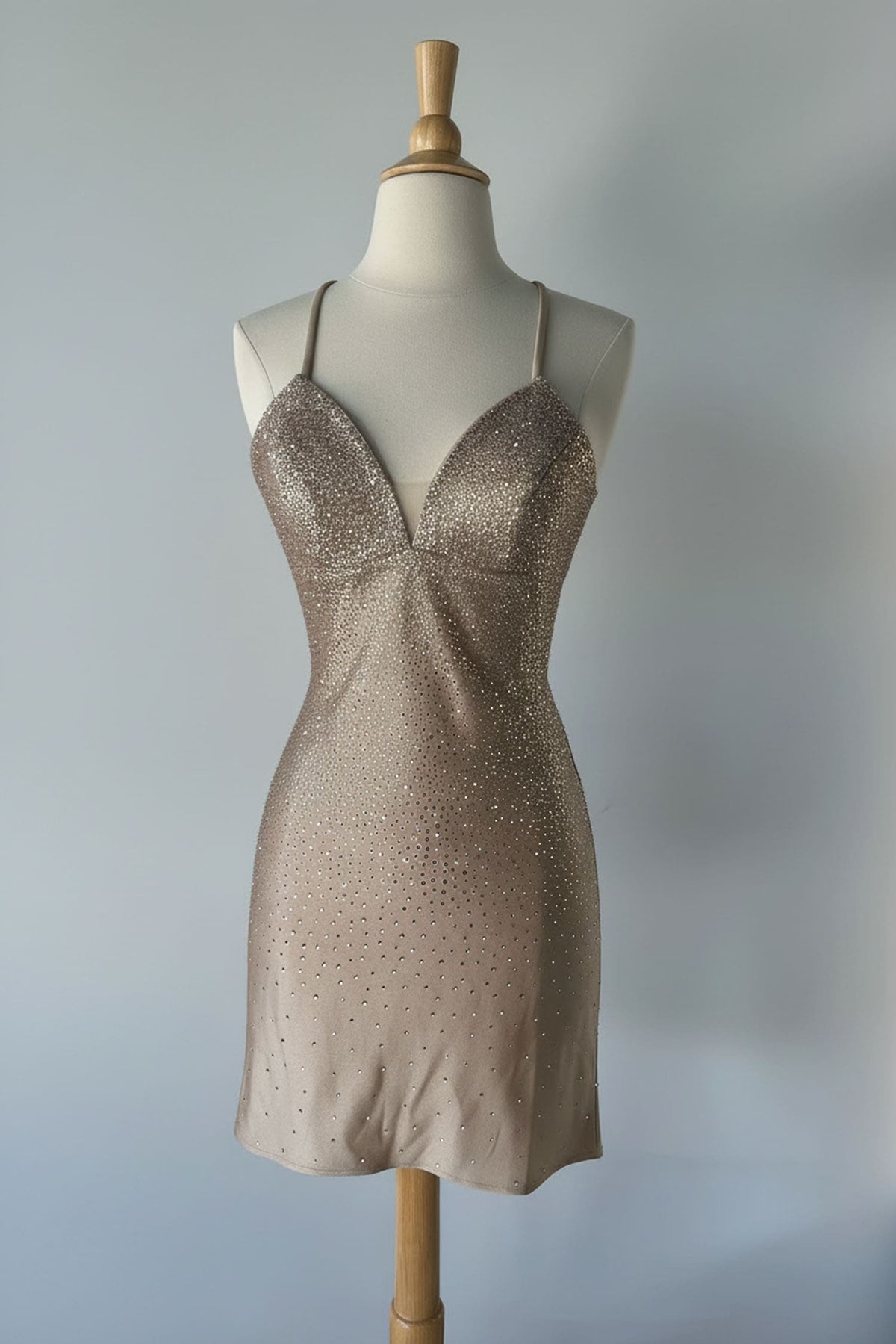 Beige slip dress on a mannequin against a gray background