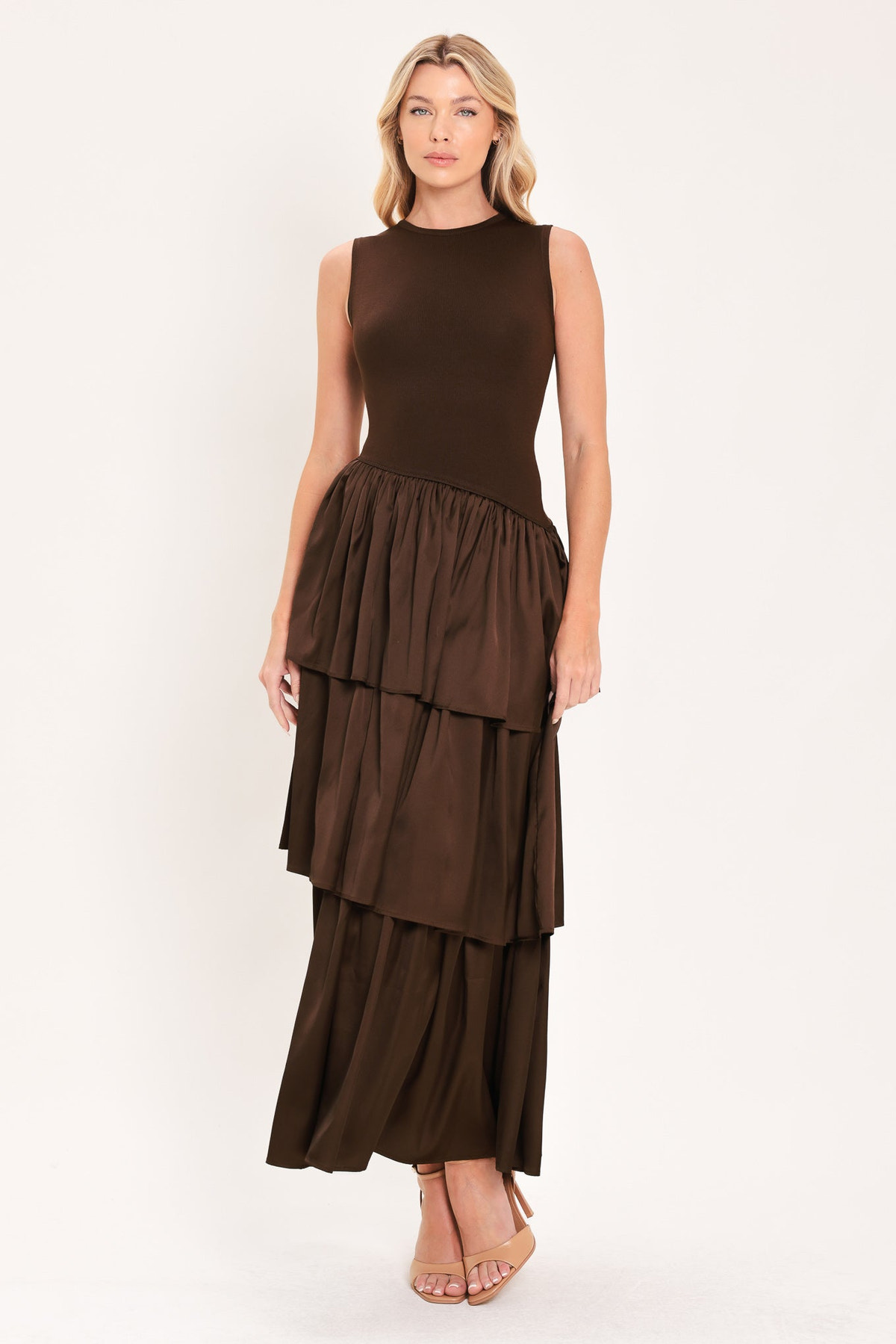 Cocoa Cascade Drop Waist Midi Dress | Lady Black Tie | A woman modeling a sleeveless dark brown dress with a fitted bodice and a tiered maxi skirt