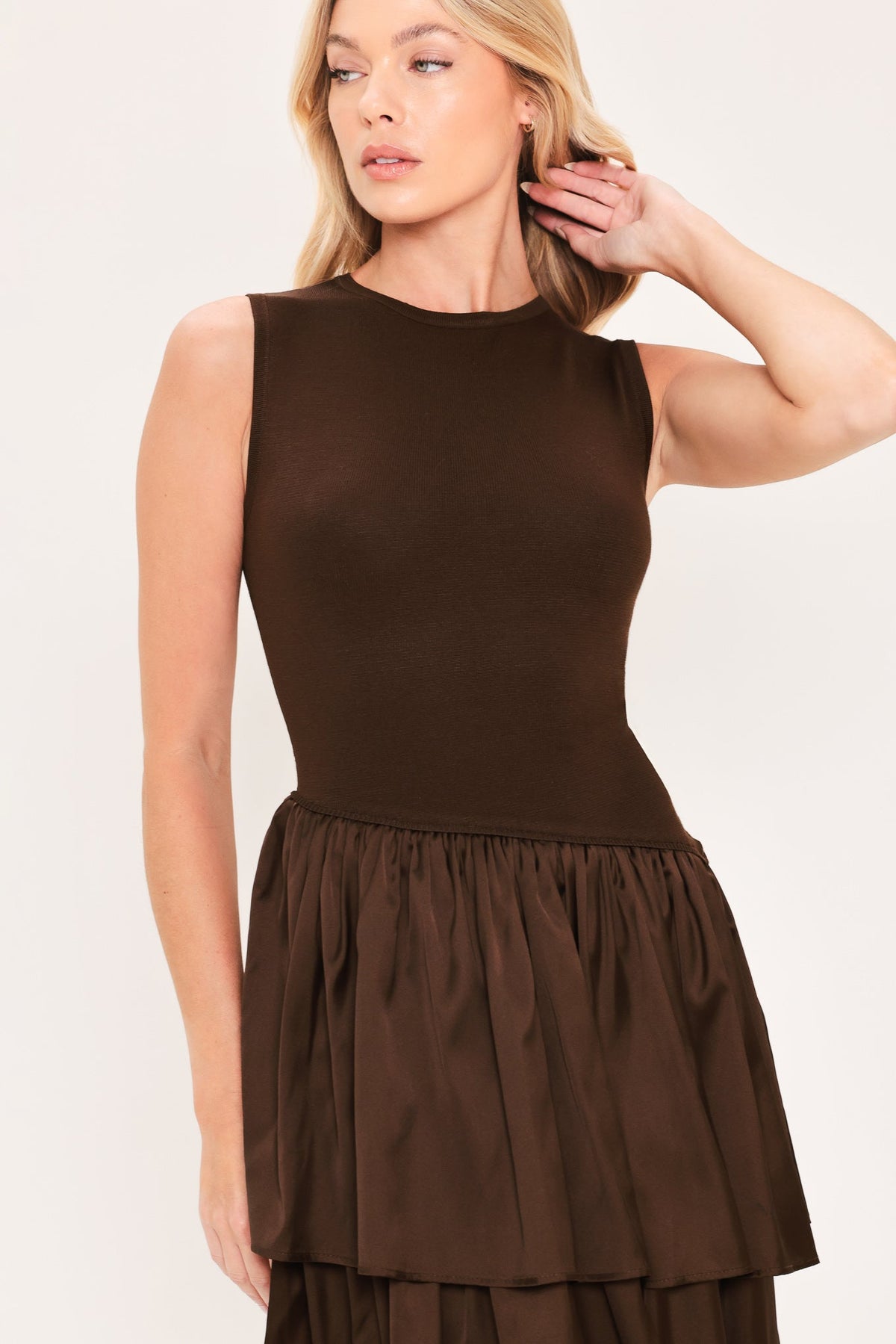 Cocoa Cascade Drop Waist Midi Dress | Lady Black Tie | A woman modeling a sleeveless dark brown dress with a fitted bodice and a tiered maxi skirt