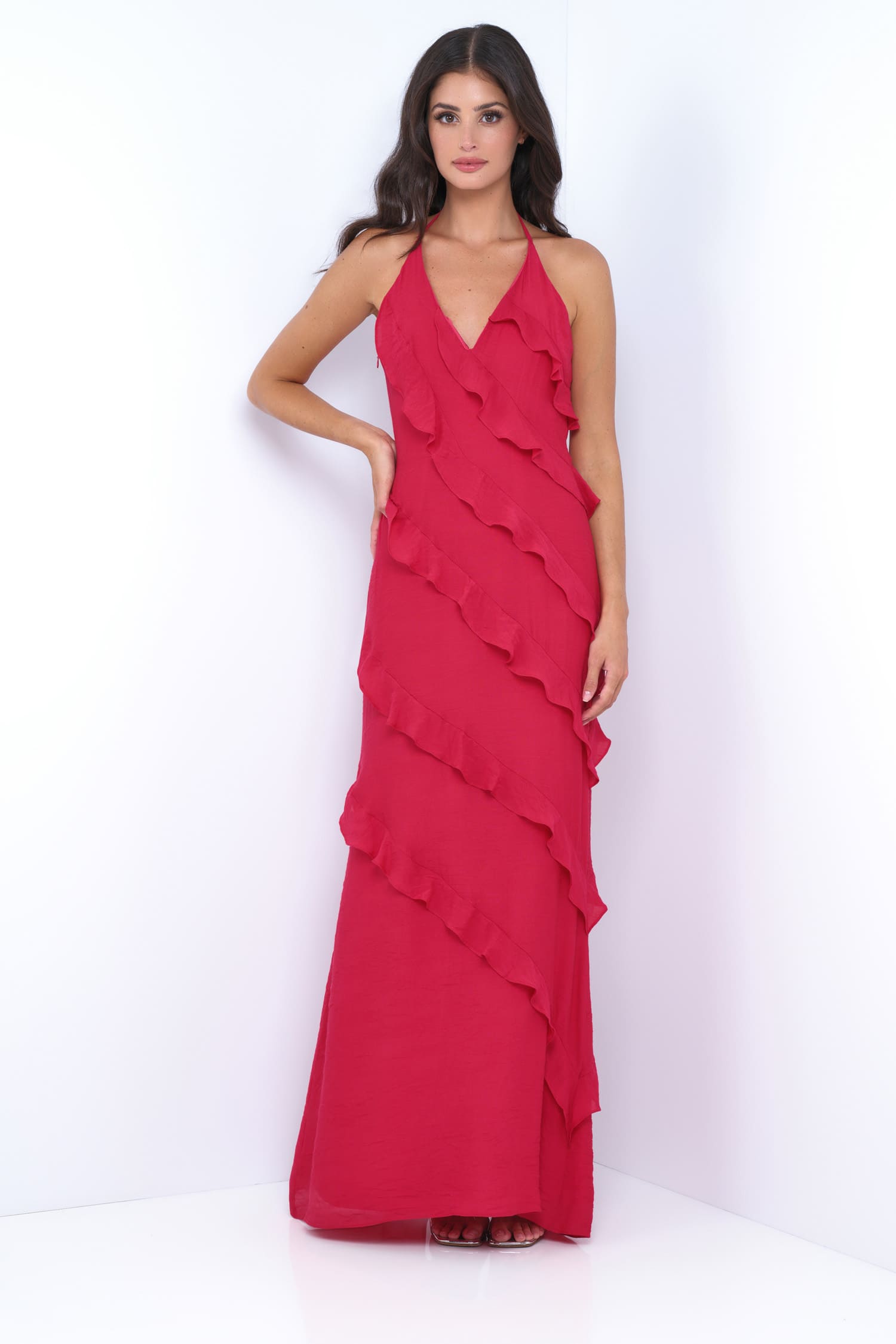 Woman wearing a red ruffled evening gown on a white background