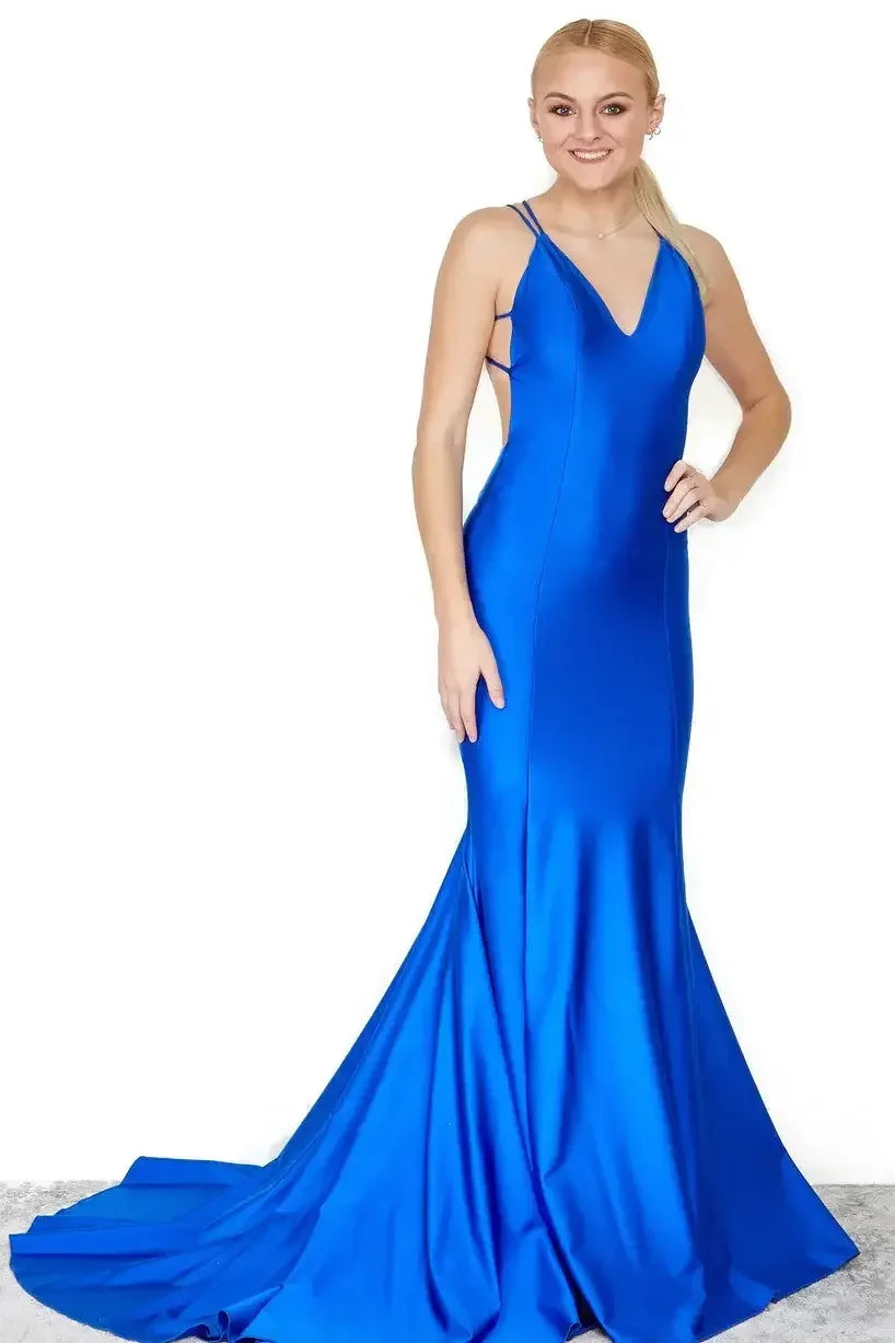 A woman stands elegantly in a vibrant blue gown with a fitted bodice and a flowing skirt. She smiles confidently against a plain white background, showcasing the dress's sleek design.