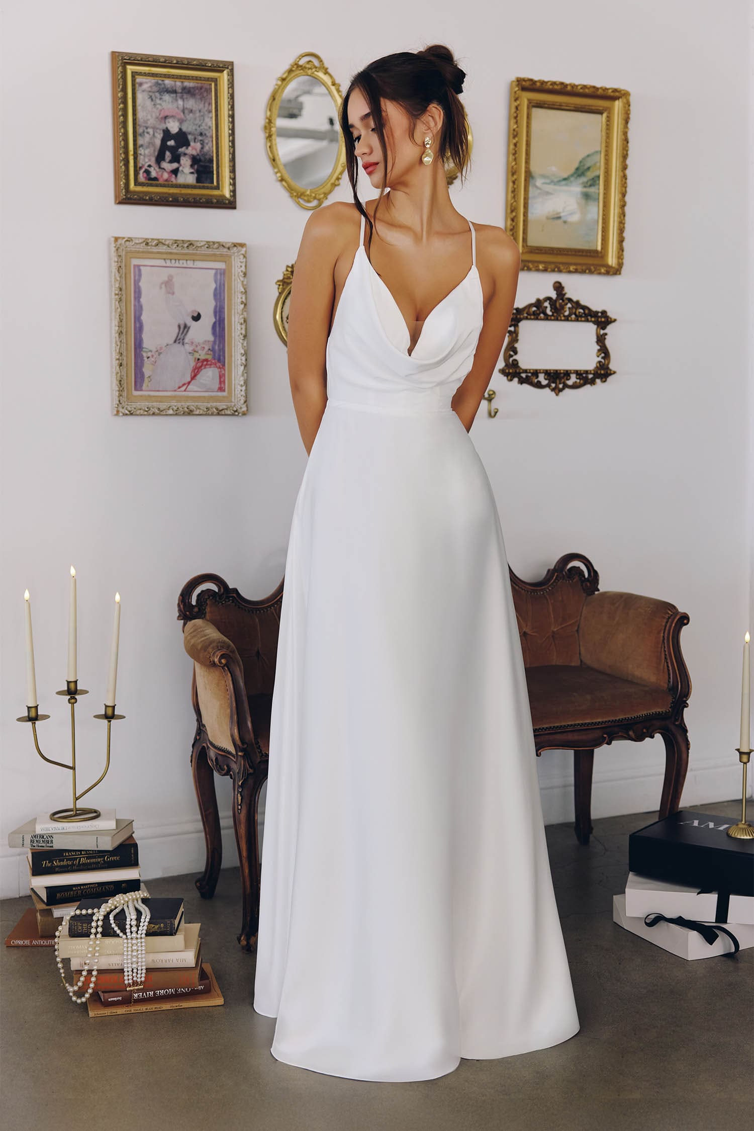 Woman in a white dress standing in a room with decorative elements.