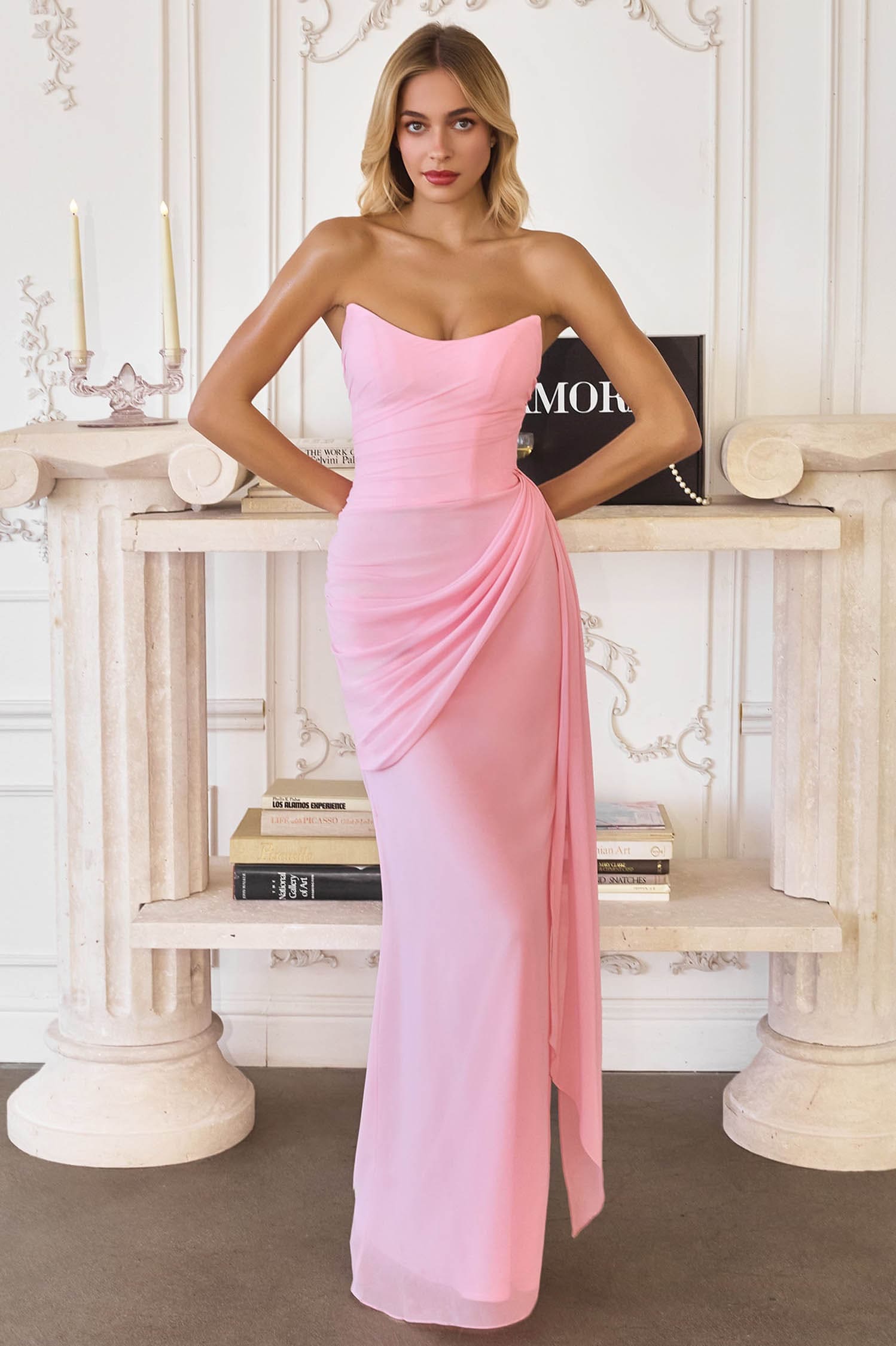 Woman wearing a pink strapless gown in an elegant interior setting.