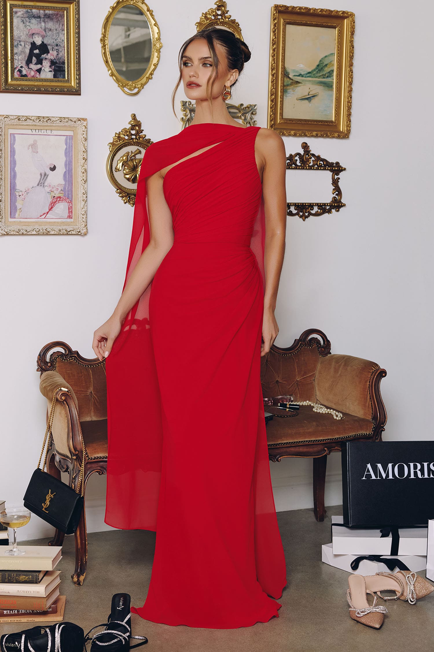 Woman in a red dress standing in a room with vintage decor and furniture.