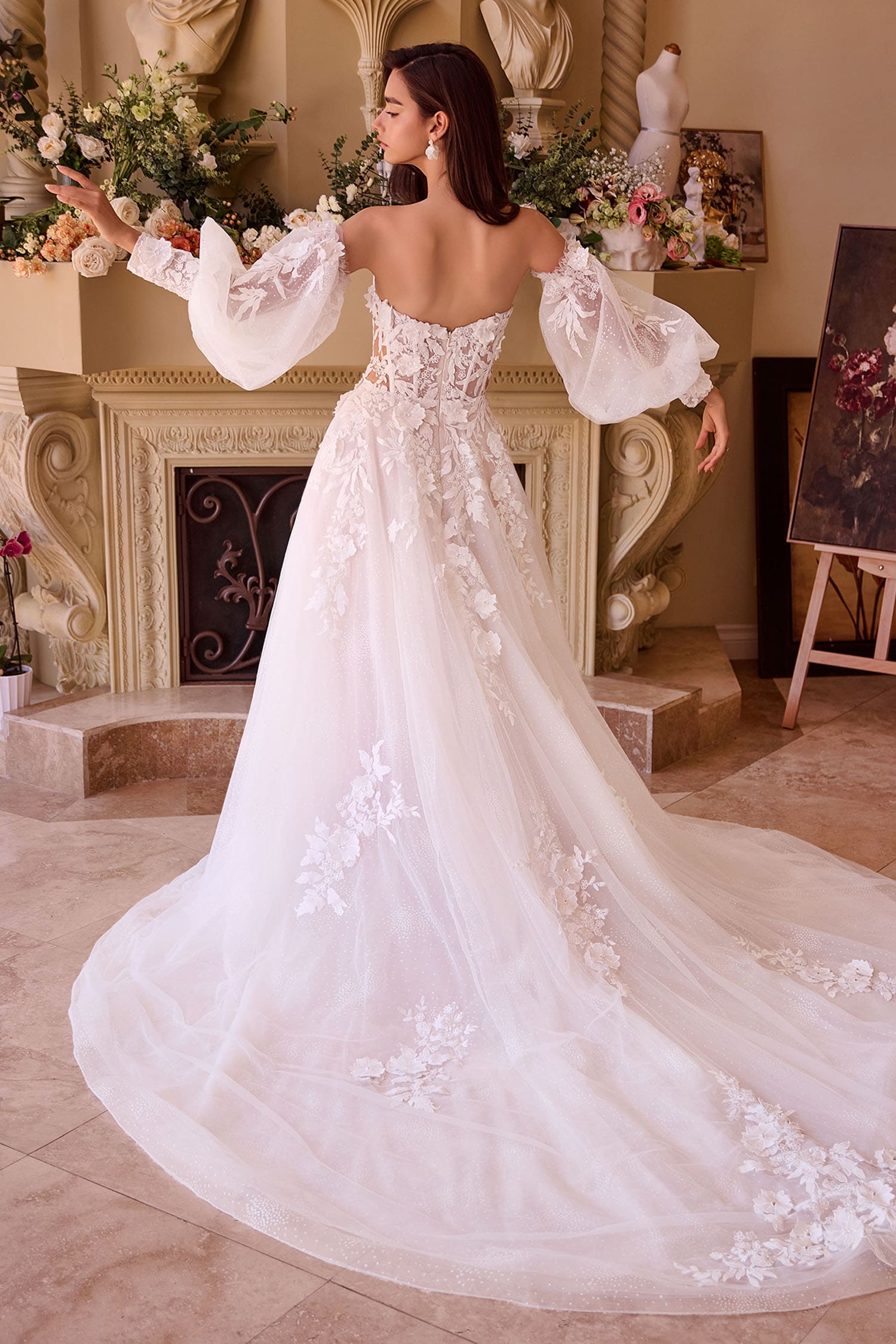 Woman in a white wedding dress with floral details in an elegant room.