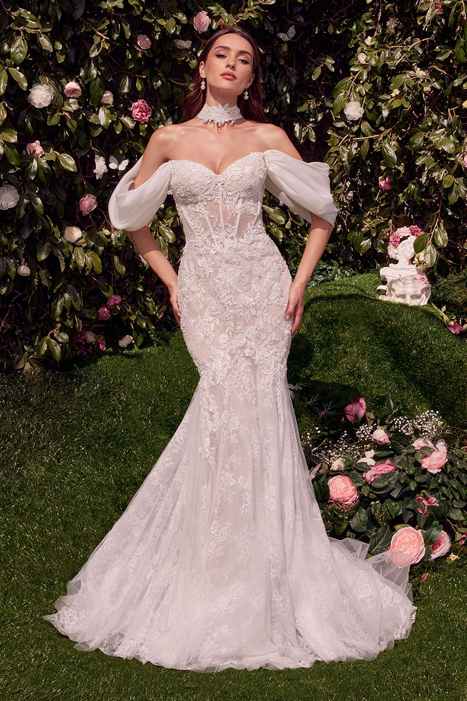 Woman in a white wedding dress standing in a garden with flowers