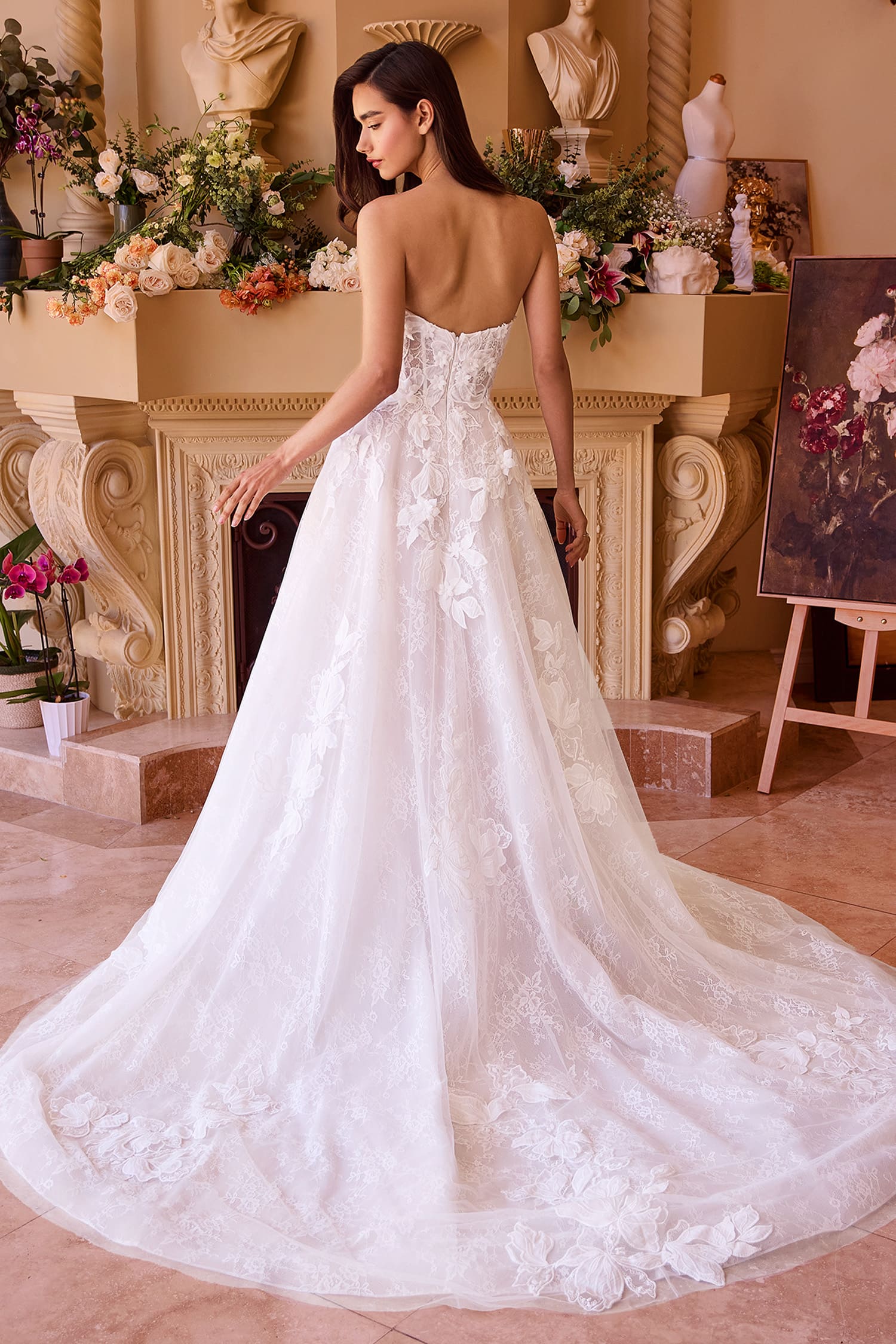 Woman in a white wedding dress with floral details in an elegant room.