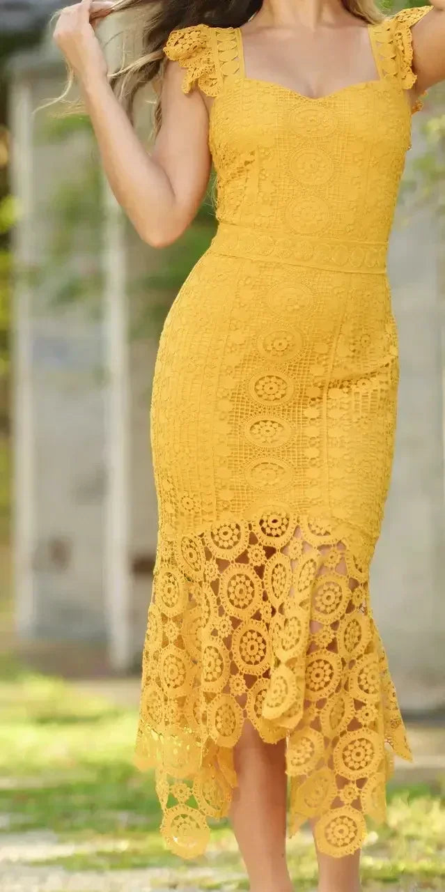 A yellow lace dress with a fitted bodice and intricate cut-out patterns flows into a wavy hemline. The setting features soft natural light and blurred greenery in the background.