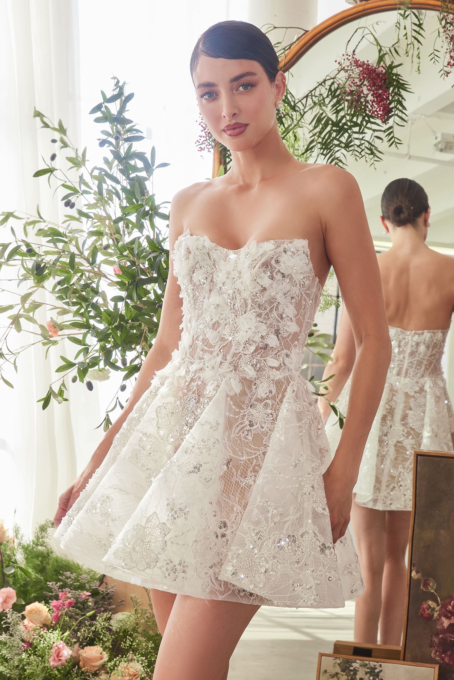 Woman wearing a strapless lace dress in a floral setting