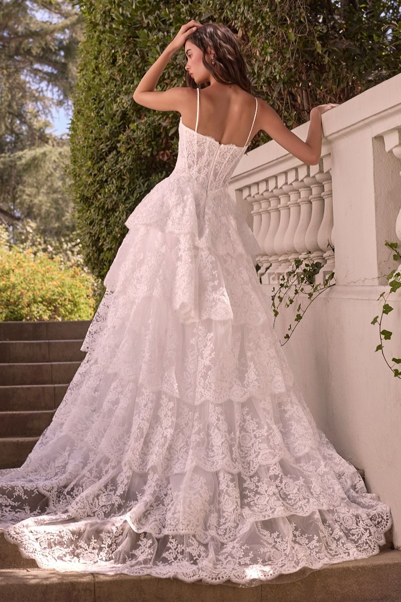 WL076 - LAYERED SCALLOP LACE A-LINE GOWN - Andrea & Leo | Lady Black Tie | A woman wearing a white lace wedding gown with thin straps and a tiered ruffled skirt.